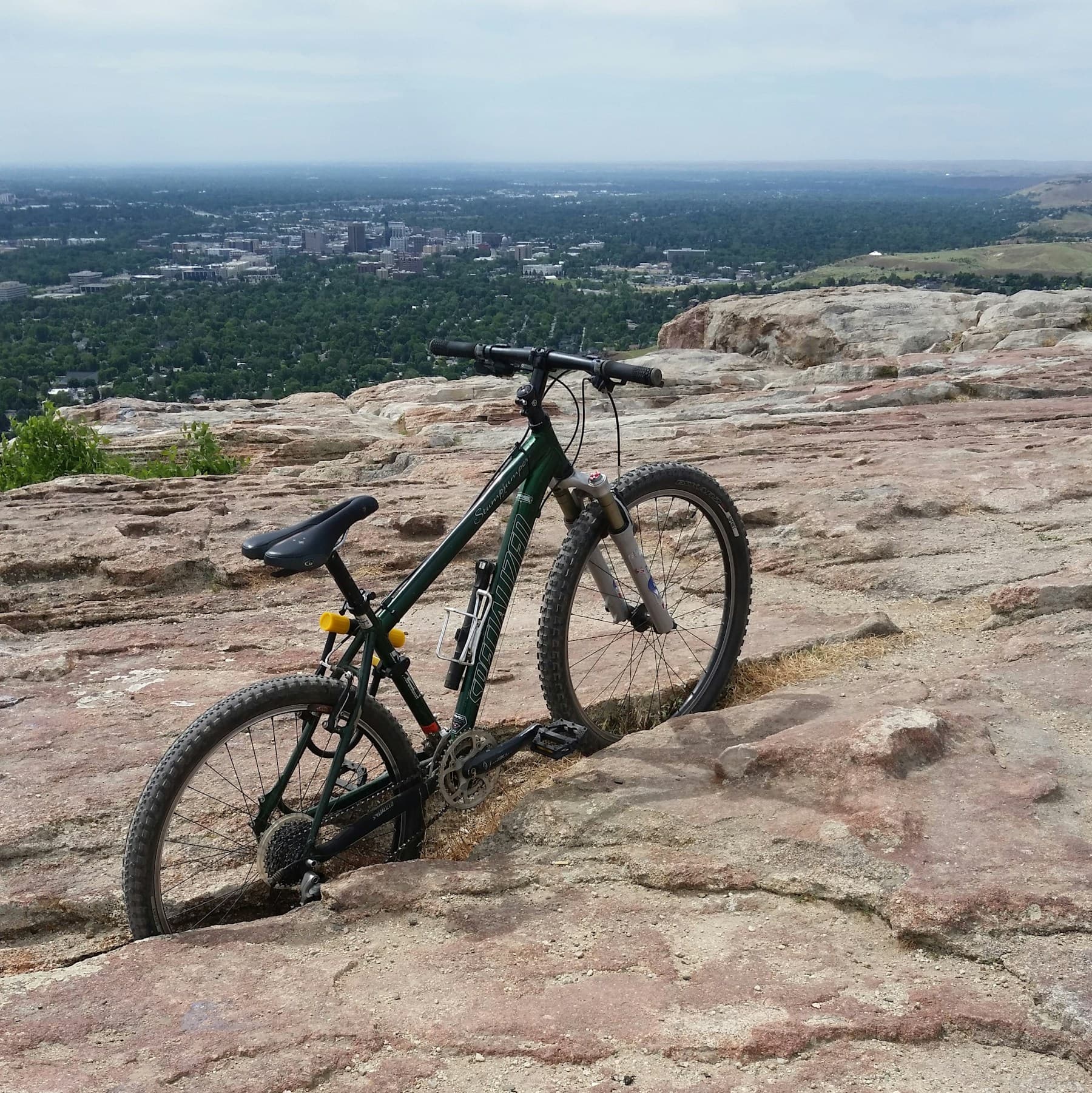 Mountain bike on a rocky Table Rock overlook with Boise in the distance